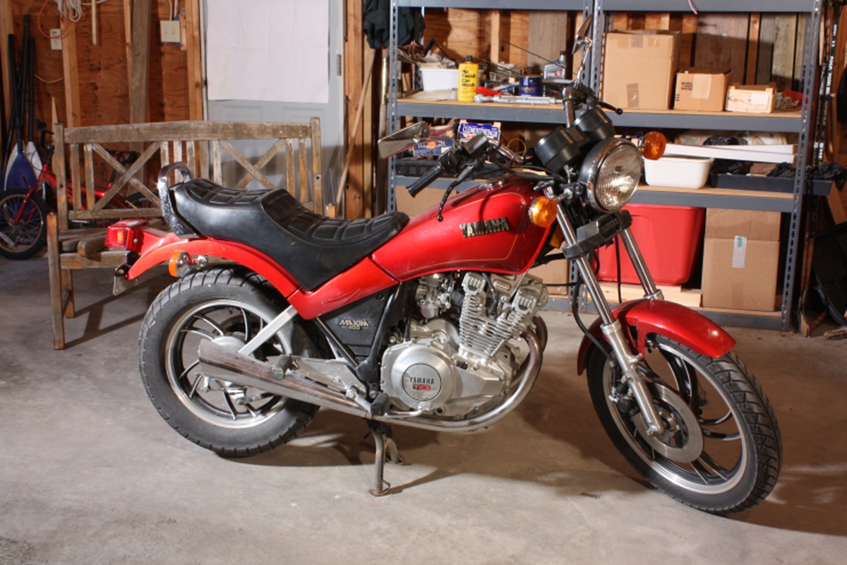 A red motorcycle photographed in a workshop-like setting.
