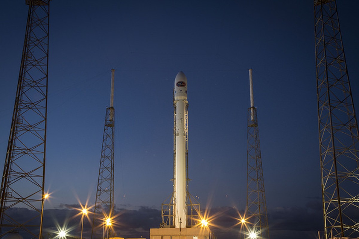 A rocket on its launch structure at dusk.